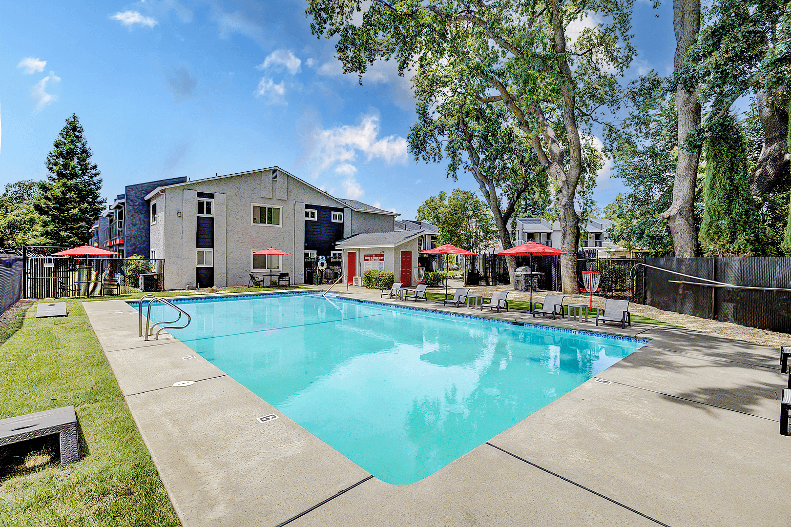 A swimming pool surrounded by trees and a building.